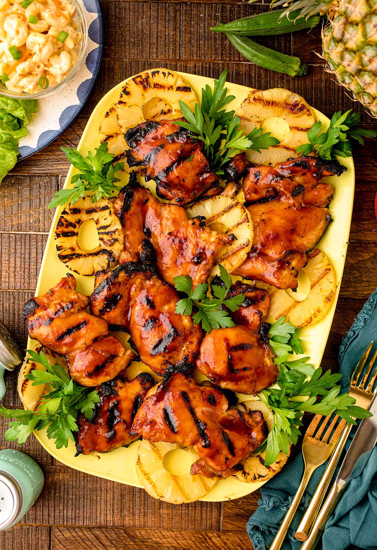 Grilled pineapple BBQ chicken on a yellow serving platter.