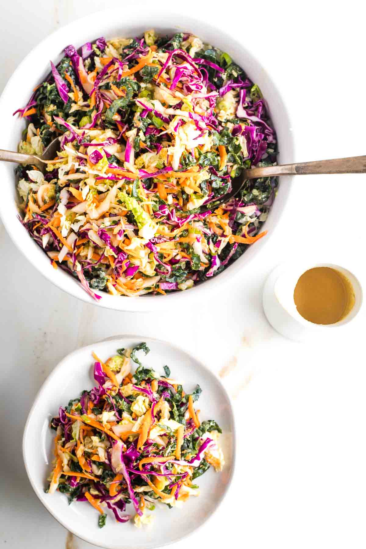 Cabbage slaw with ginger dressing on a plate and in a large serving bowl.