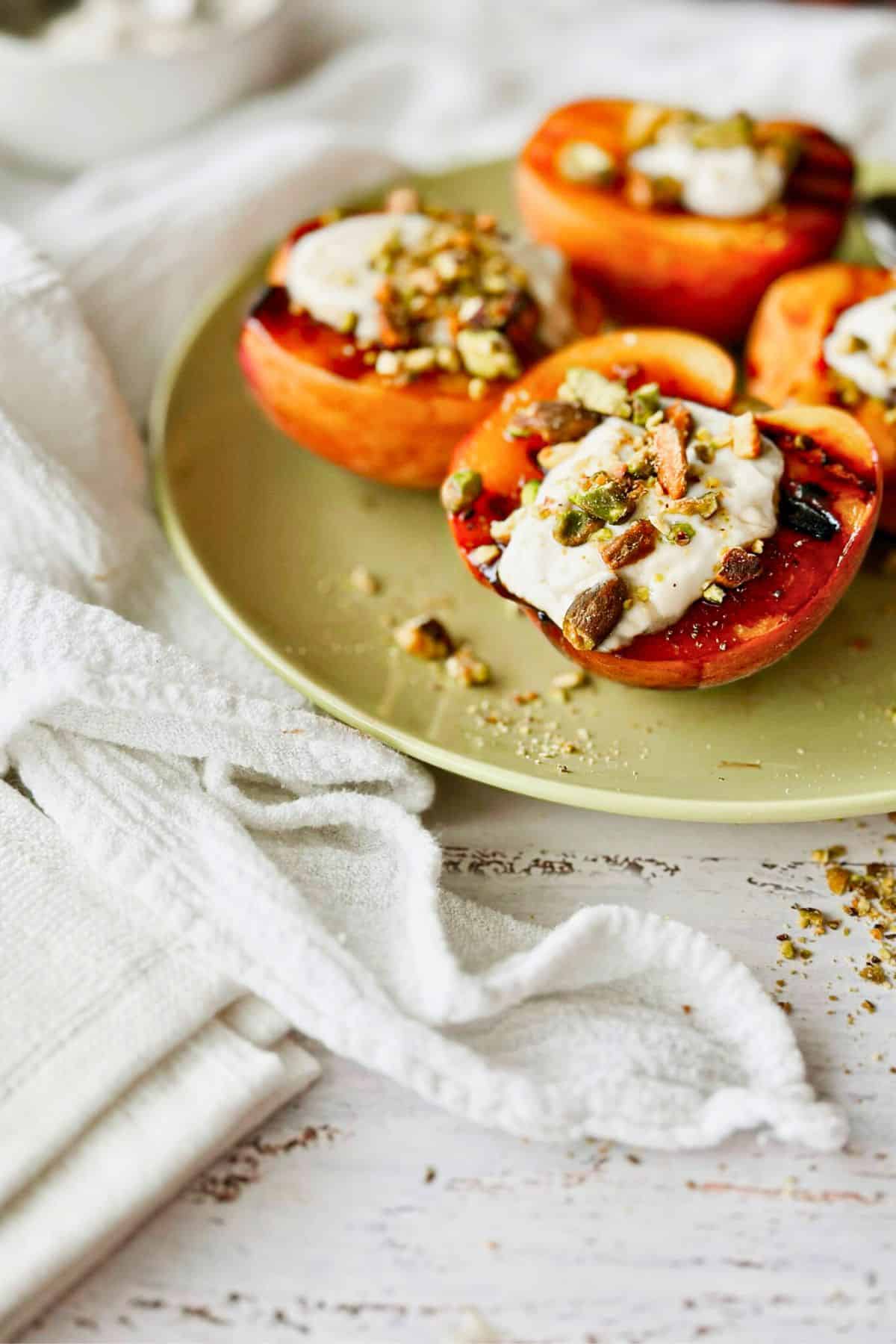 Grilled peaches with mascarpone cheese and nuts on top.