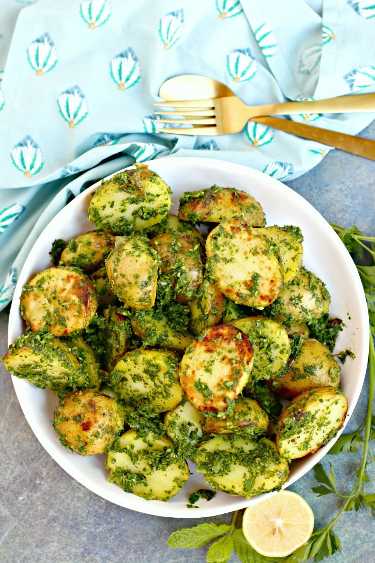 Green potato salad without mayo in large white bowl.