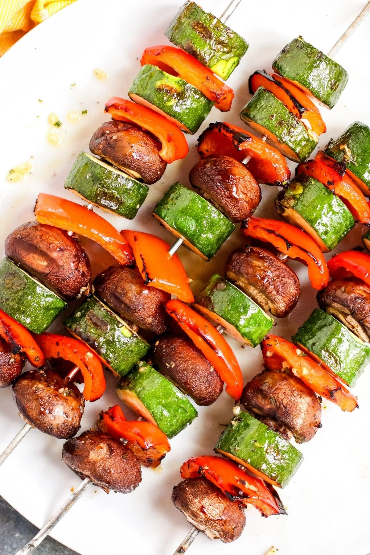 Grilled Mediterranean vegetable skewers on a large white serving platter.