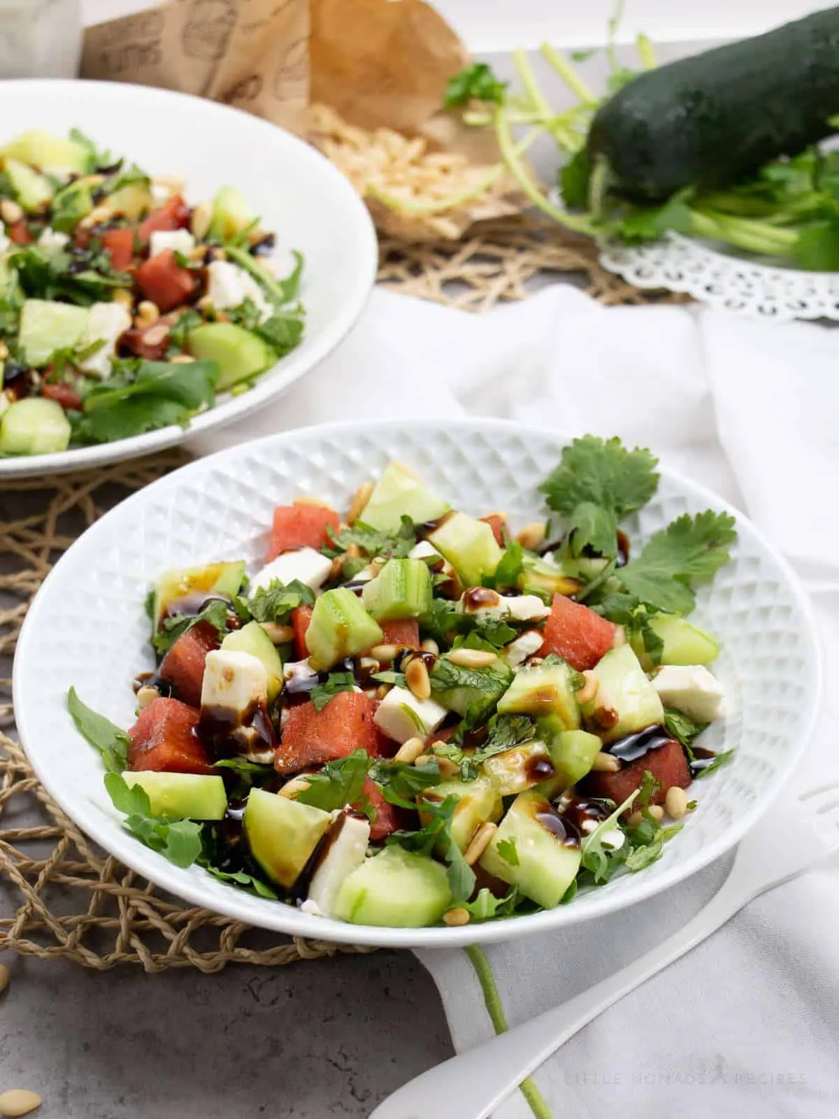 Cucumber watermelon salad with cilantro in a white bowl.