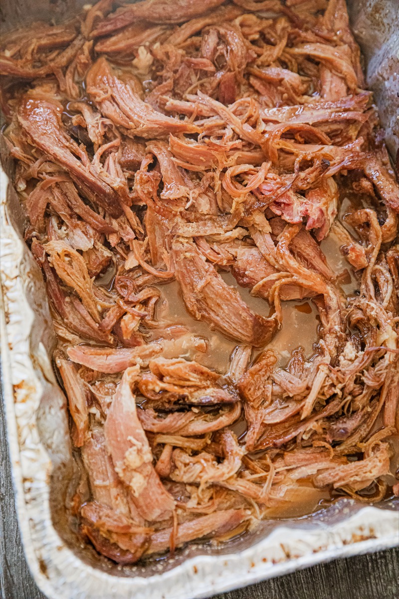 Smoked pulled pork on a large silver serving platter.