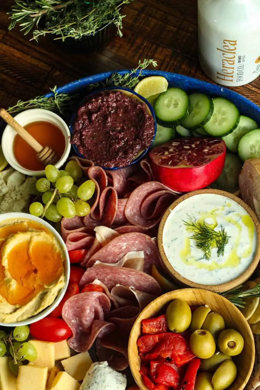 Mediterranean diet charcuterie board with meat, veggies, fruit, dips, and spreads.