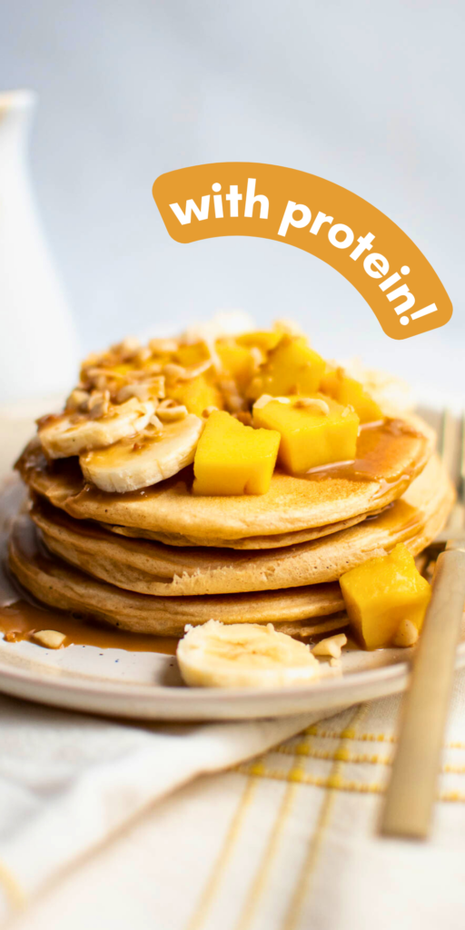 Stack of pancakes with fresh tropical fruit and text that reads "with protein!"