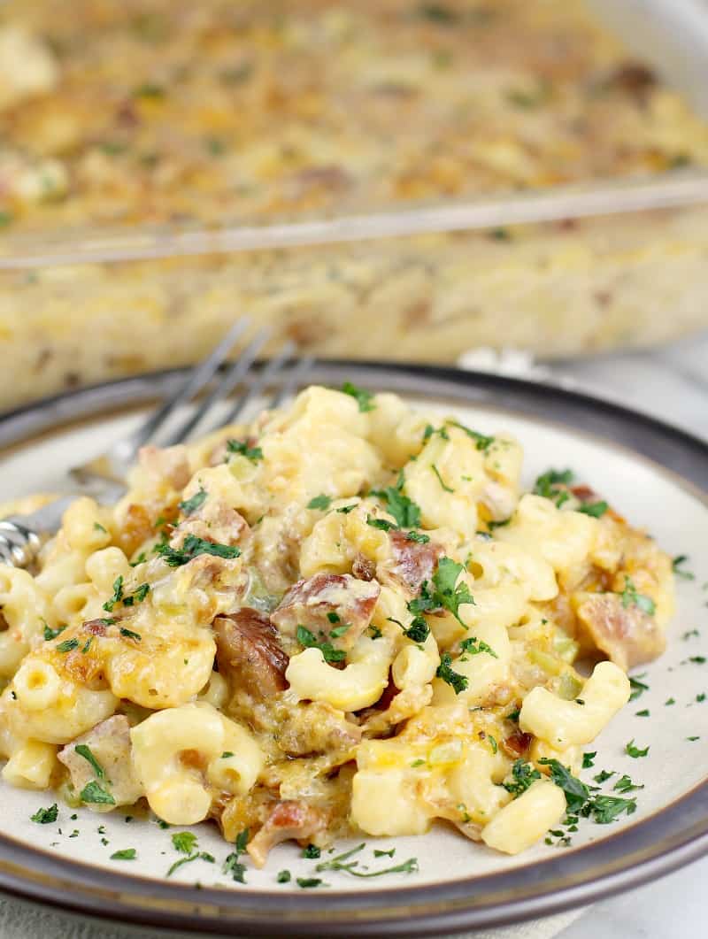 Cajun macaroni on a white plate with green onion.