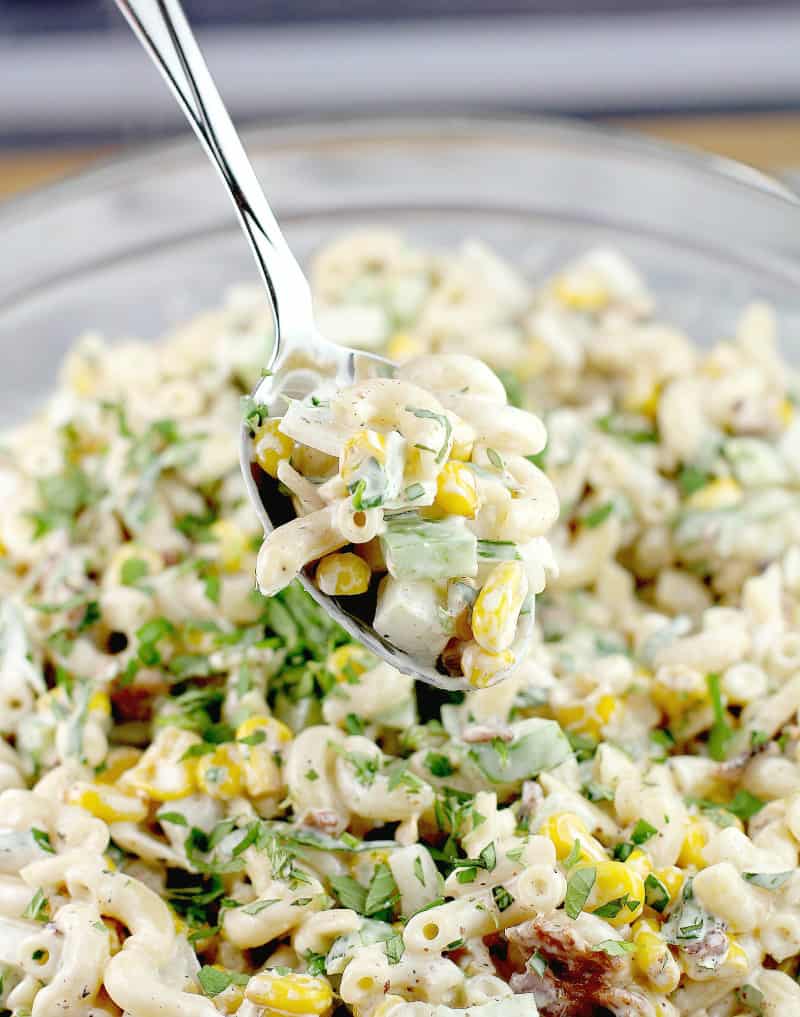 Cajun macaroni pasta with corn and green garnish.