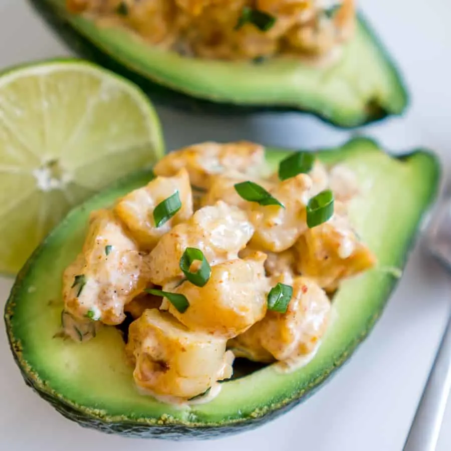 Cajun shrimp stuffed avocados with green garnish.