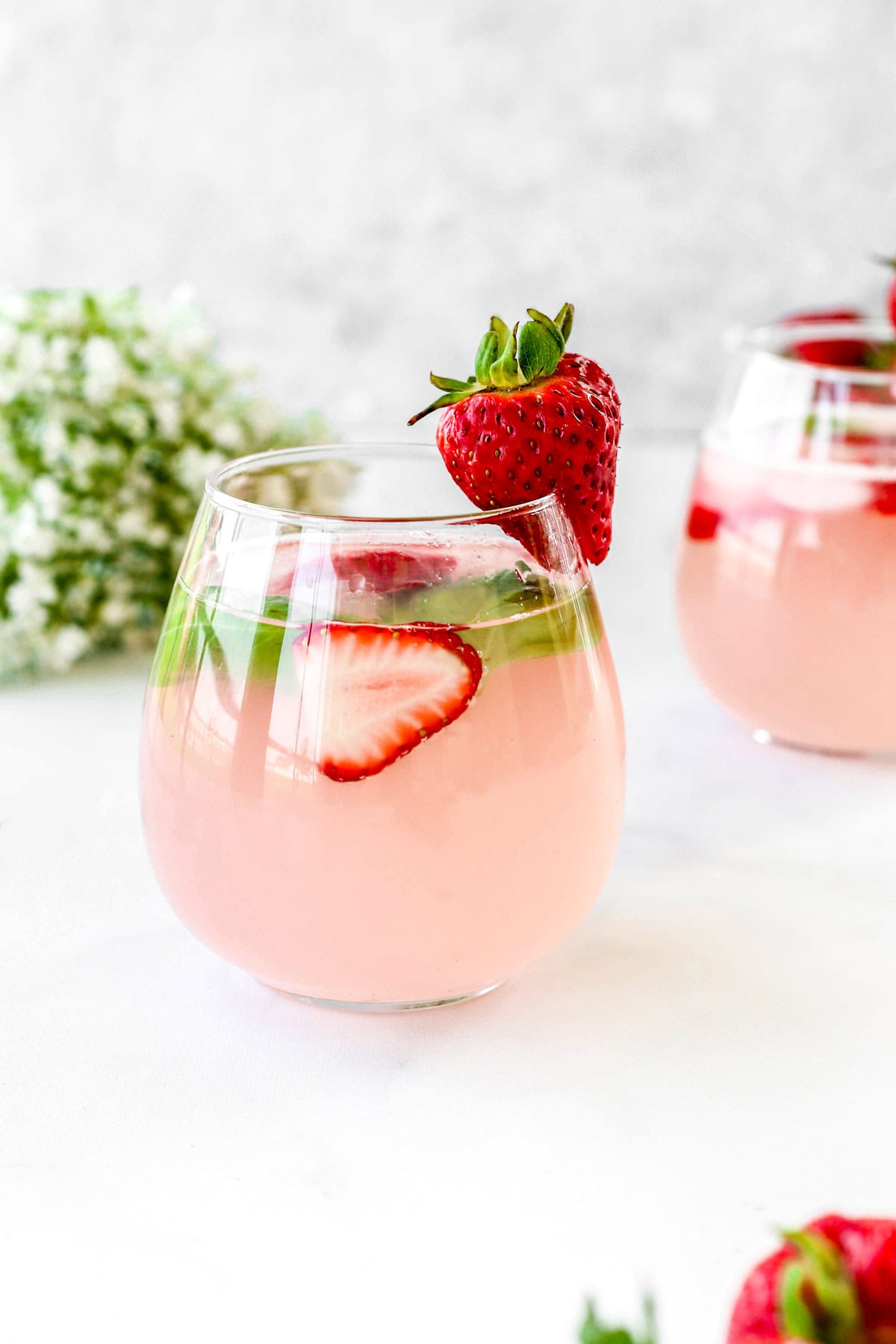 A strawberry mocktail with fresh strawberries for garnish.