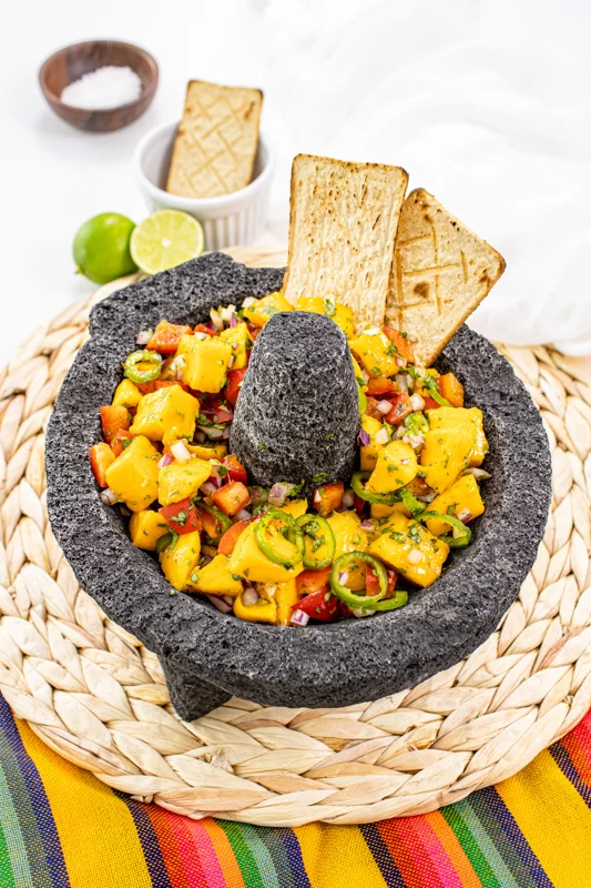 Mango salsa in a molcajete with tortilla chips.