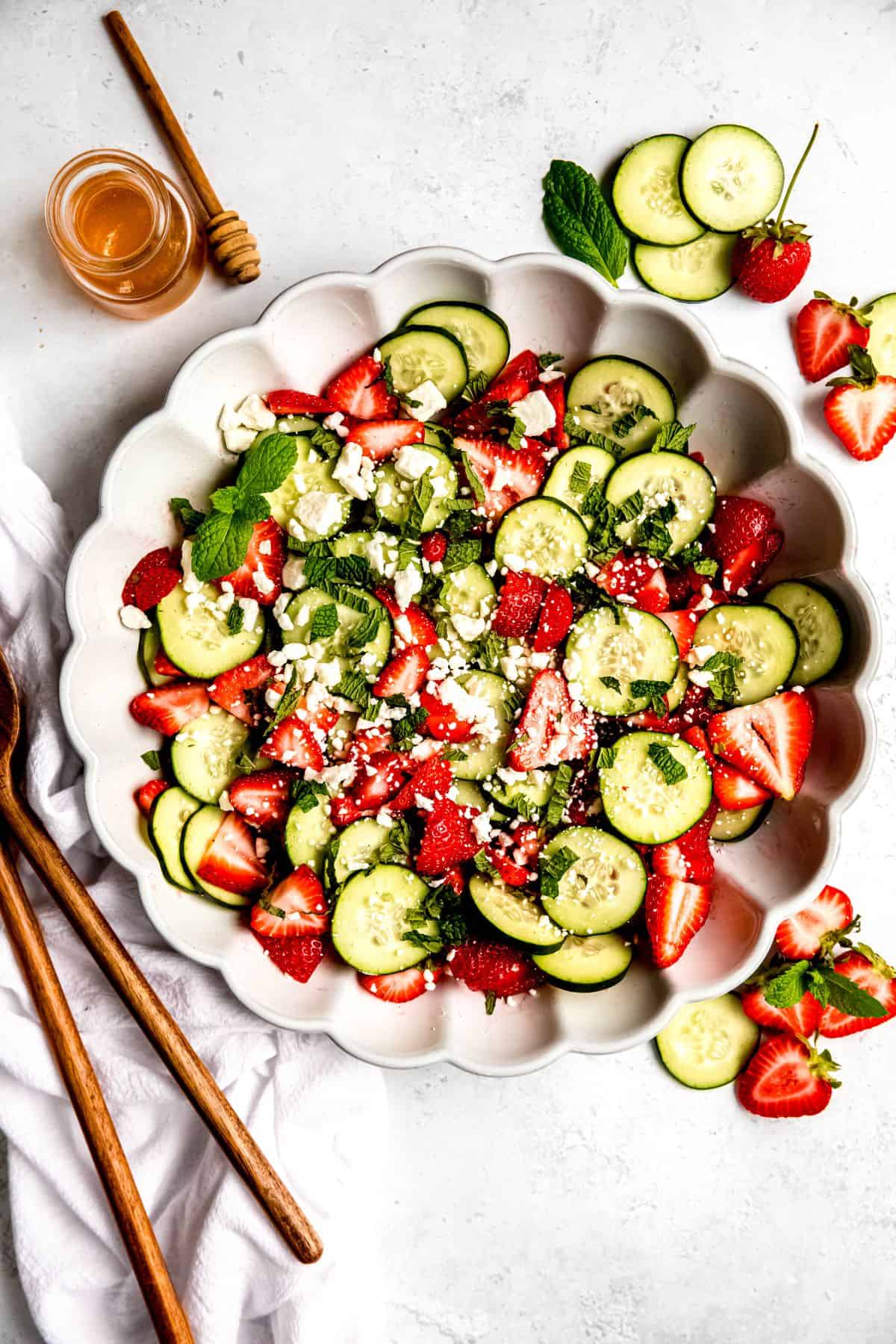 Strawberry cucumber salad on a decorative white plate.