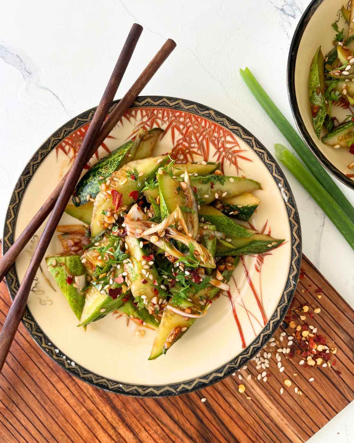 Spicy Asian cucumber salad with diagonally sliced cucumbers and sesame seeds.