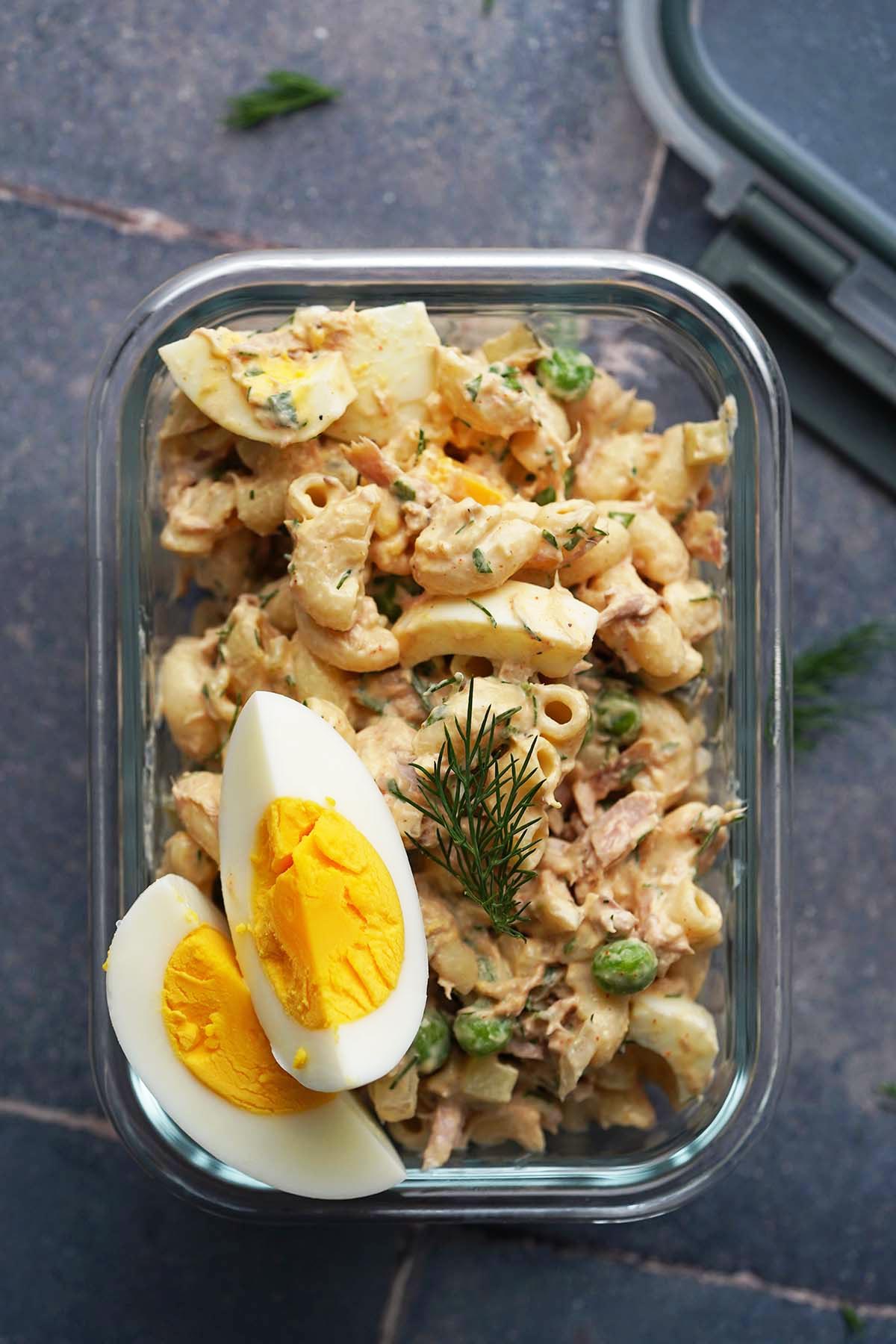 Creamy protein pasta salad with tun in a glass meal prep container.