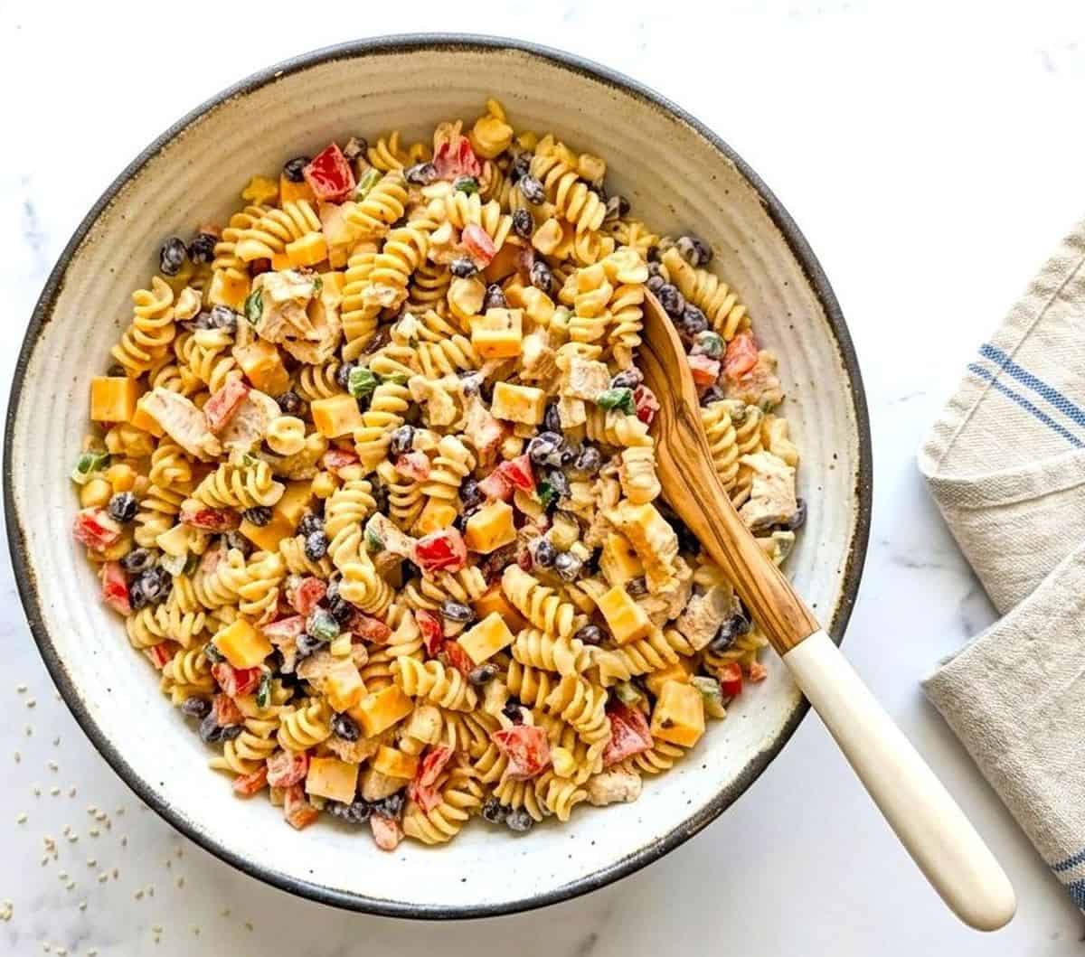 Southwest chicken pasta salad in a white bowl with summer veggies.