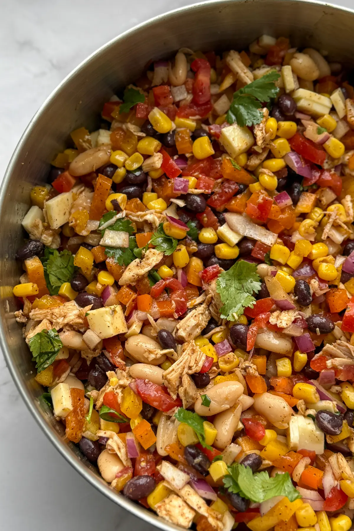 Mexican dense bean salad with shredded chicken, corn, tomatoes, and two kinds of beans.