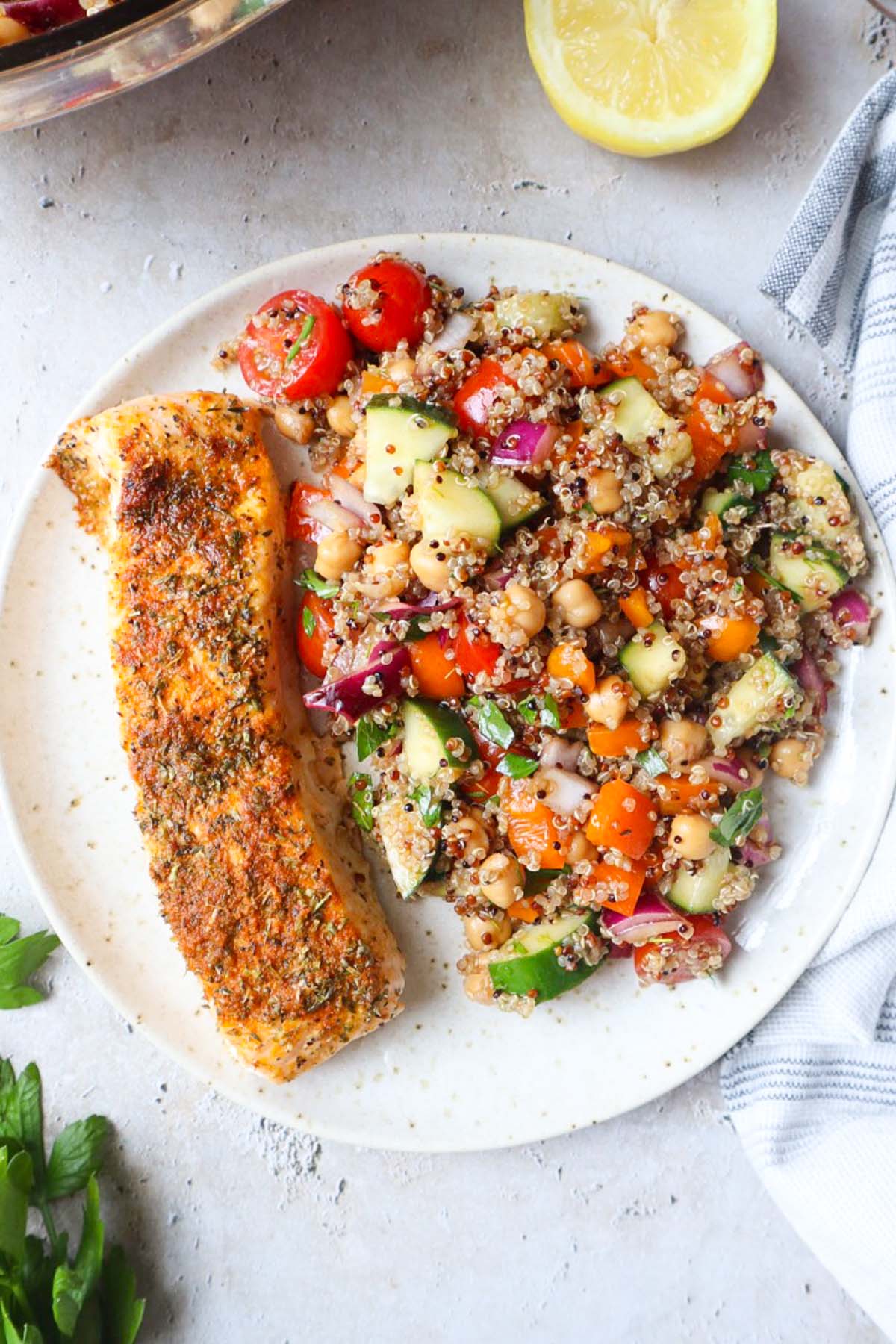 Salmon quinoa salad with tomatoes, cucumbers, and peppers.