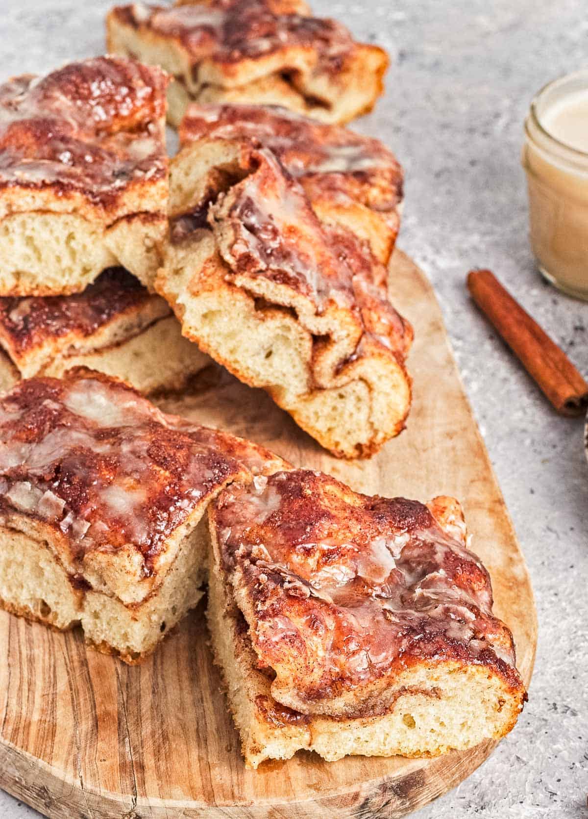 Slices of cinnamon roll focaccia bread on a wooden cutting board.