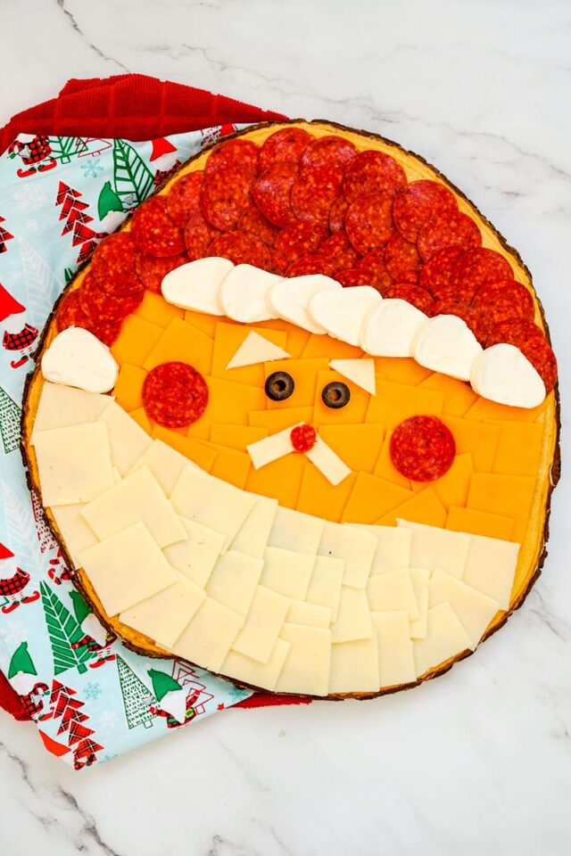 A Santa charcuterie board made from cheese, crackers, and pepperoni.