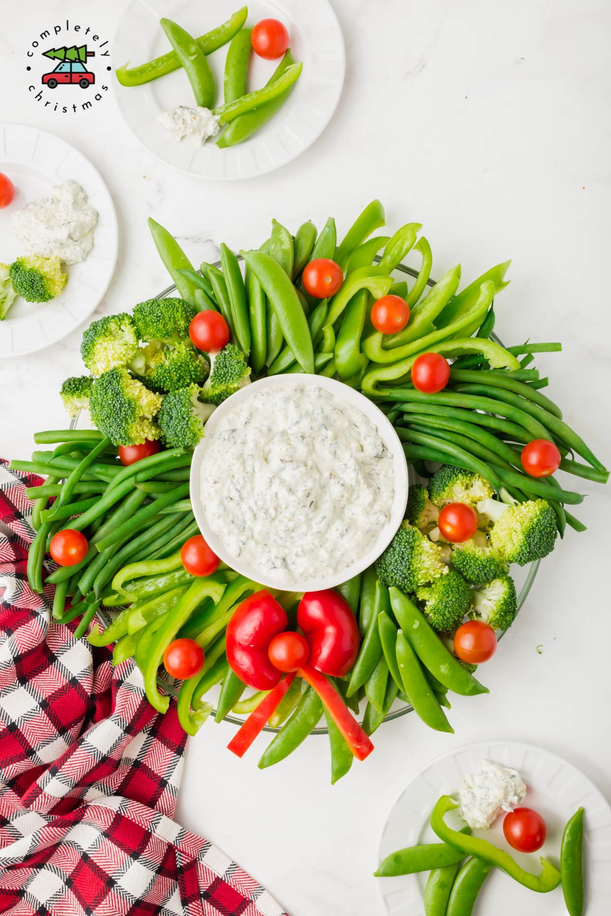 A veggie wreath made from snap peas, broccoli, bell peppers, and grape tomatoes.