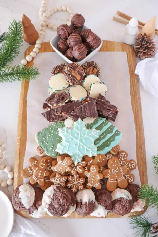 A Christmas tree dessert charcuterie board with cookies, pastries, and treats.