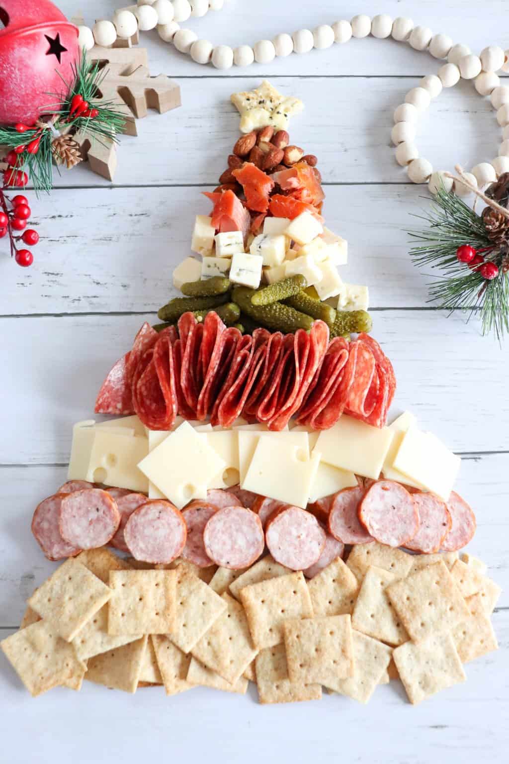 A cheese and crackers Christmas tree charcuterie board with ham and pepperoni.