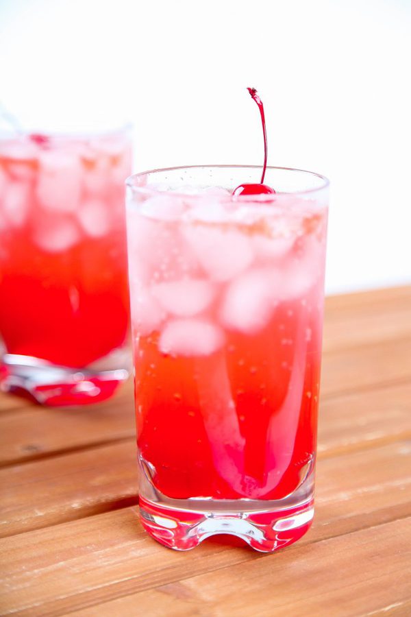 Two Shirley temples in medium glasses with cherry garnish.