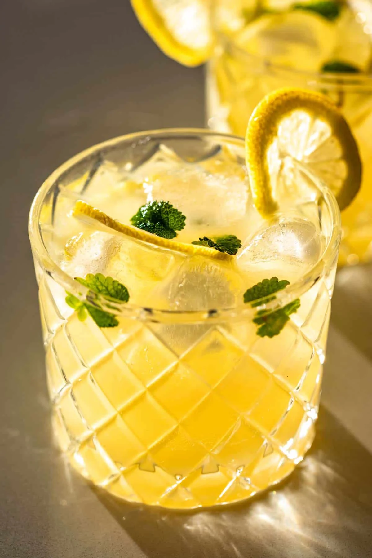 Ginger Beer mocktail in two small glasses with mint and lemon garnish.