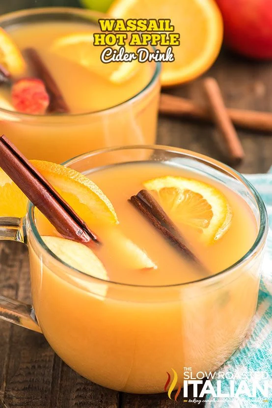 Wassail Christmas drinks in short glasses with lemon and cinnamon stick garnish.