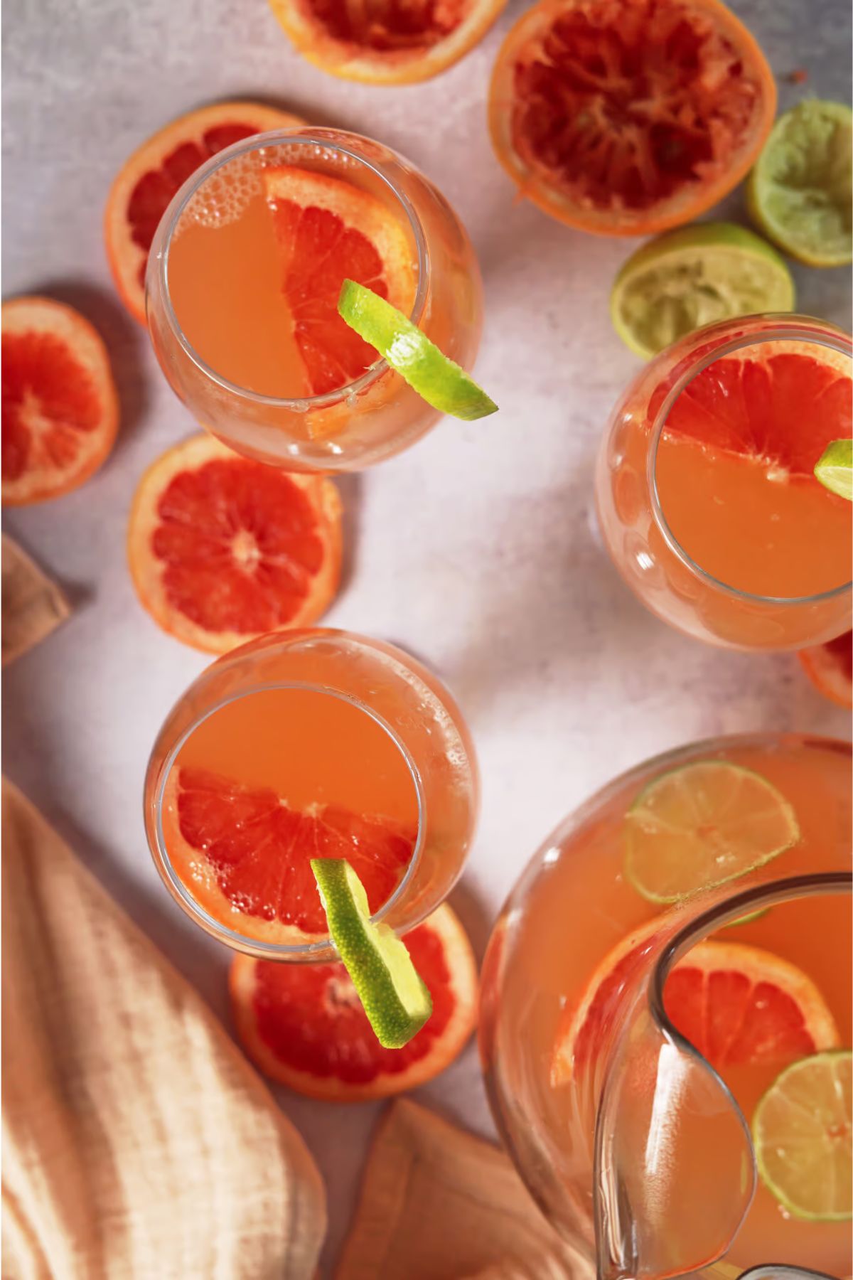 Grapefruit mocktails with lemon garnish and sliced grapefruit all around.