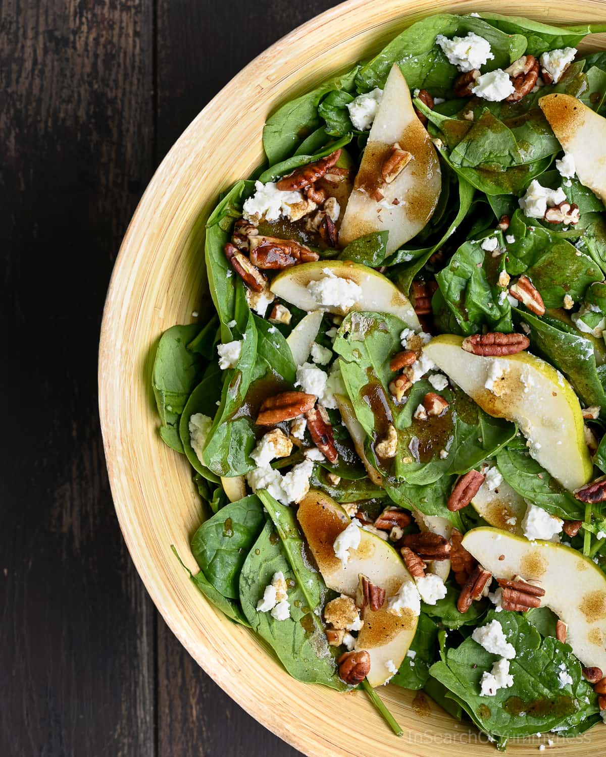 Spinach and pear salad with pecans and white cheese.