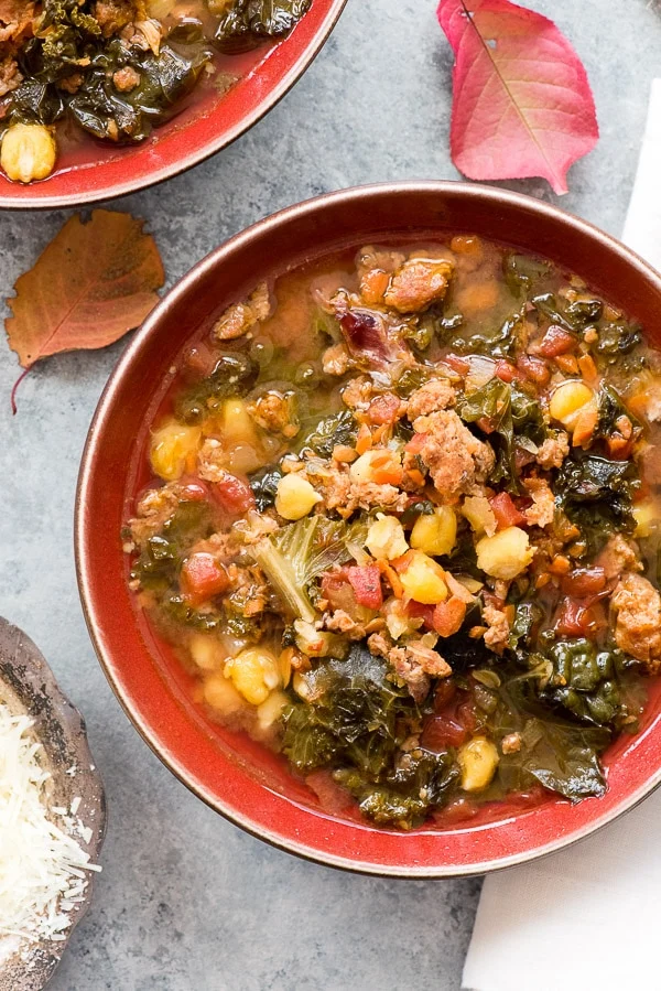 Chorizo kale soup with beans two red bowls.