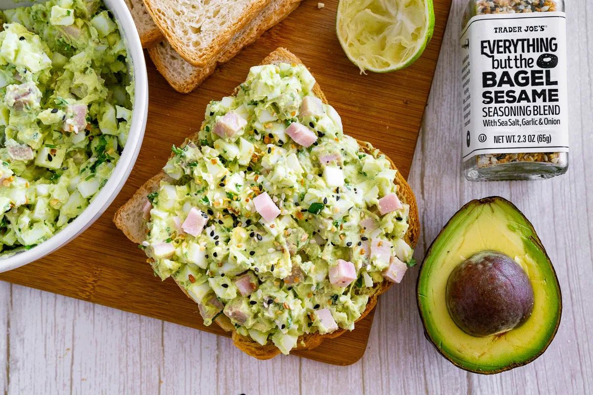 Ham and egg salad on toast next to an avocado and a bottle of everything bagel seasoning.
