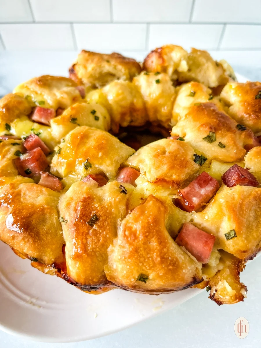 Ham and cheese pull-apart bread on a white serving dish.