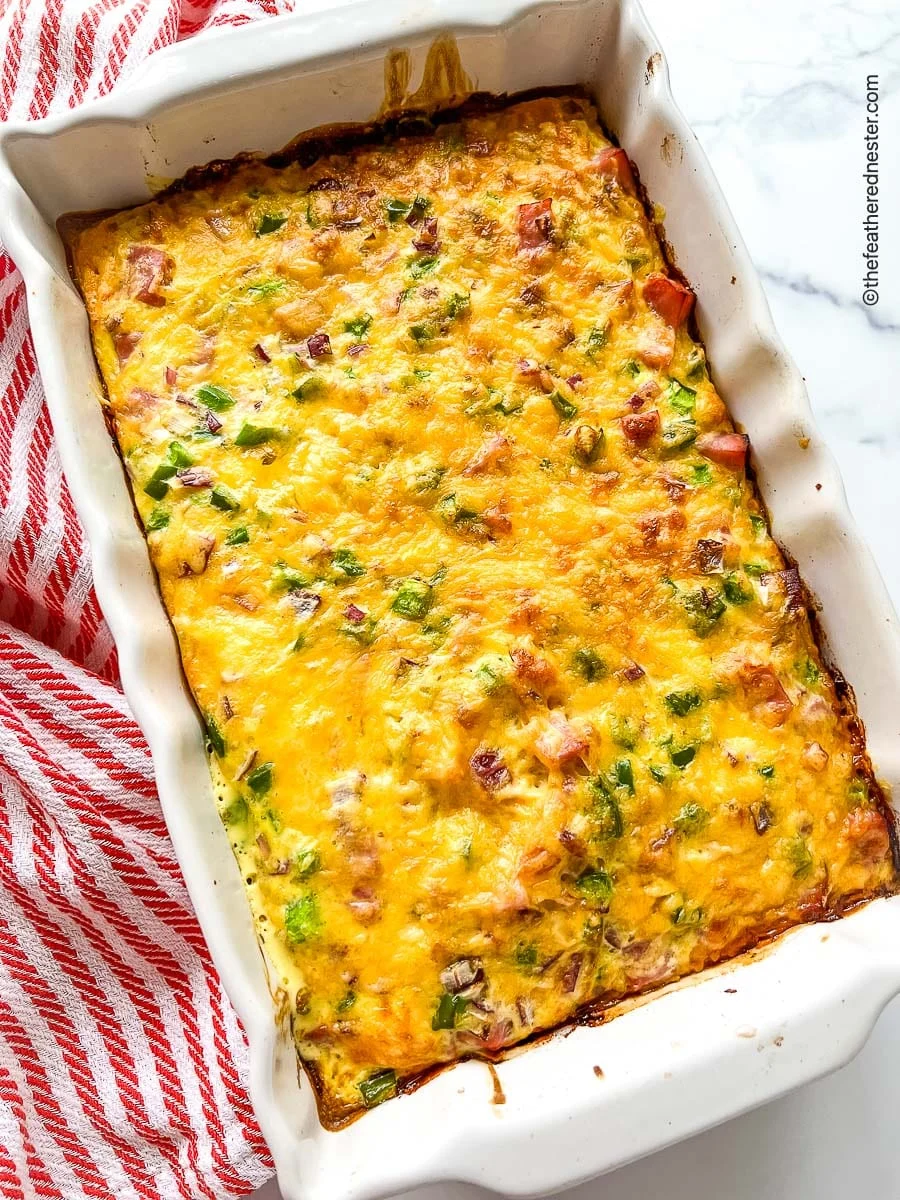 Ham and tater tot casserole in a rectangular white baking dish,