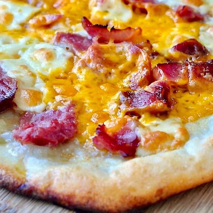 Thin crust pizza with ham and cheese.