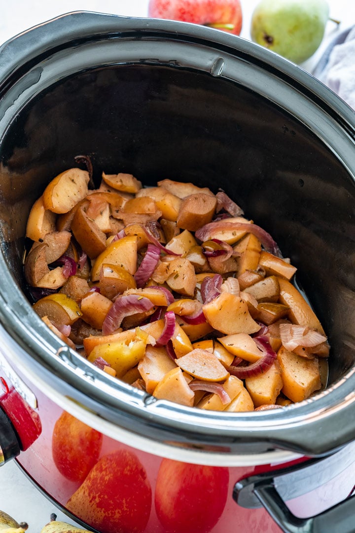 Crockpot apples and onions in a large red crockpot.